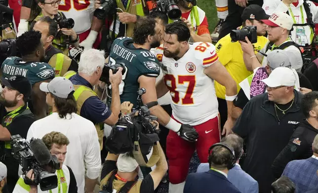 Philadelphia Eagles tight end Dallas Goedert (88) and Kansas City Chiefs tight end Travis Kelce (87) greet each other after the NFL Super Bowl 59 football game, Sunday, Feb. 9, 2025, in New Orleans. (AP Photo/Charlie Riedel)
