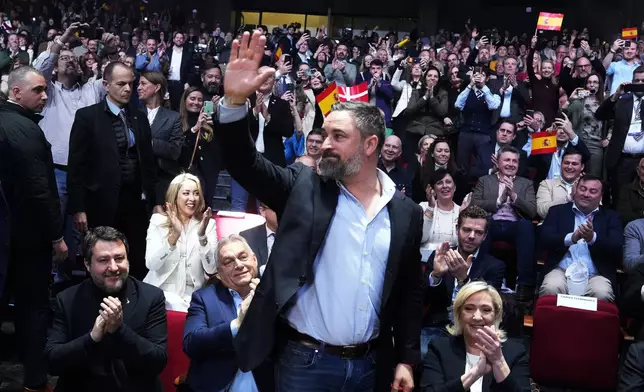 Spanish far-right VOX party leader Santiago Abascal, centre, waves next to European far-right politicians during the Patriots for Europe summit in Madrid, Spain, Saturday, Feb. 8, 2025. From left, Italy's vice Premier Matteo Salvini, Hungarian Prime Minister Viktor Orban, far-right VOX party leader Santiago Abascal and French far-right leader Marine Le Pen. (AP Photo/Paul White)