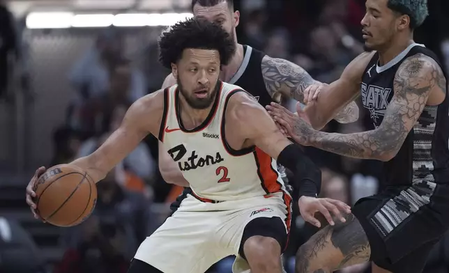 Detroit Pistons guard Cade Cunningham (2) is pressured by San Antonio Spurs forward Jeremy Sochan, right, during the second half of an NBA basketball game in Austin, Texas, Friday, Feb. 21, 2025. (AP Photo/Eric Gay)