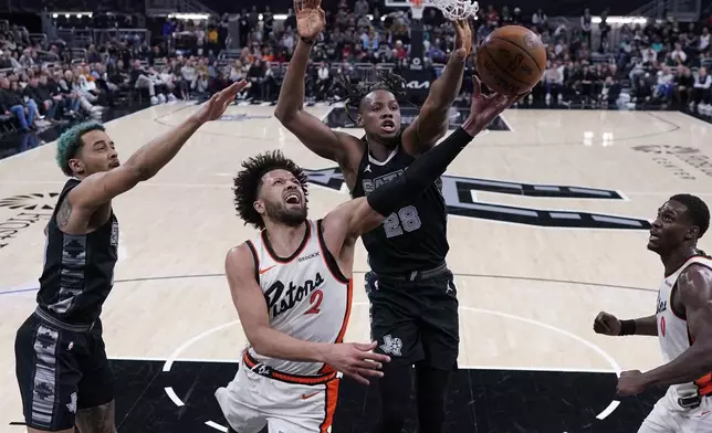 Detroit Pistons guard Cade Cunningham (2) tries to score against San Antonio Spurs center Charles Bassey (28) during the first half of an NBA basketball game in Austin, Texas, Friday, Feb. 21, 2025. (AP Photo/Eric Gay)