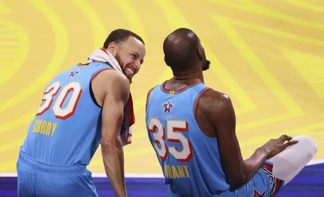 Golden State Warriors guard Stephen Curry talks to Phoenix Suns forward Kevin Durant during the NBA All-Star basketball game Sunday, Feb. 16, 2025, in San Francisco. (AP Photo/Jed Jacobsohn)