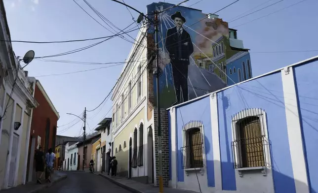 A mural dedicated to Dr. José Gregorio Hernández blankets a building in the La Pastora neighborhood where he once practiced medicine, in Caracas, Venezuela, Tuesday, Feb. 25, 2025. Pope Francis on Tuesday approved the canonization of the physician, making him Venezuela's first saint. (AP Photo/Cristian Hernandez)
