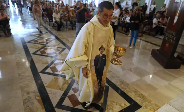 Father Gregory Lobo wears a chasuble designed with an image of Dr. Jose Gregorio Hernandez during a celebratory Mass in Caracas, Venezuela, Tuesday, Feb. 25, 2025, after Pope Francis approved the canonization of the physician known as the "doctor of the poor", making him Venezuela's first saint. (AP Photo/Cristian Hernandez)