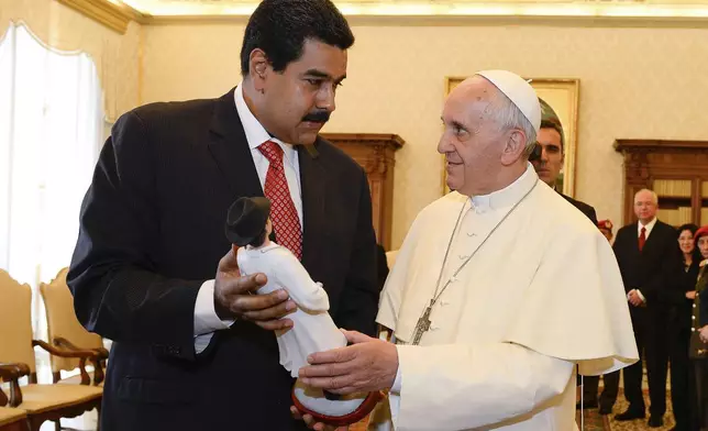 FILE - Venezuelan President Nicolas Maduro presents Pope Francis with a statuette of Dr. Jose Gregorio Hernandez, a popular figure amongst Venezuelans whom Maduro expressed hope for his canonization, on the occasion of their private audience at the Vatican, June 17, 2013. (Andreas Solaro via AP, File)