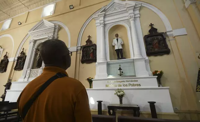 A man looks up at a statue of José Gregorio Hernandez, the physician known as the "doctor of the poor", in Valencia, Venezuela, Tuesday, Feb. 25, 2025. Pope Francis on Tuesday approved a decree to canonize Hernandez, making him Venezuela's first saint. (AP Photo/Jacinto Oliveros)