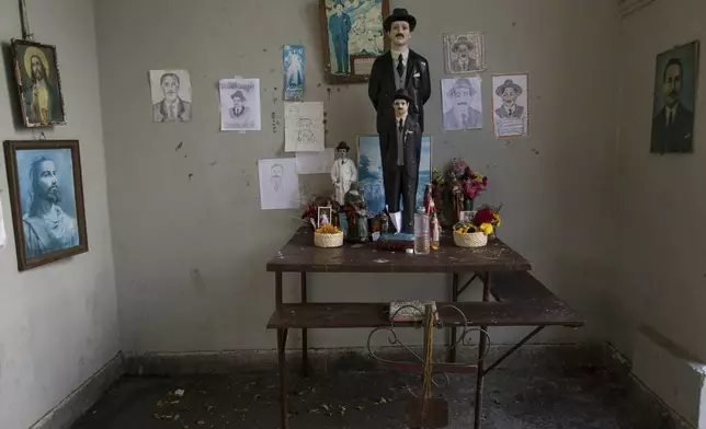 FILE - An altar dedicated to Dr. Jose Gregorio Hernandez is adorned with flowers and statues in his likeness, at the Vargas Public Hospital in Caracas, Venezuela, Feb. 5, 2019. (AP Photo/Rodrigo Abd, File)
