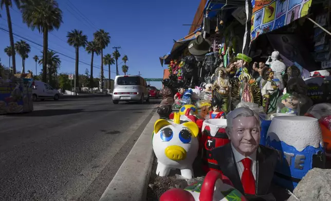 A ceramic statue depicting Mexico's former President Andres Manuel Lopez Obrador is displayed for sale among a variety of figurines at a roadside curios shop in Mexicali, Mexico, Saturday, Feb. 1, 2025. (AP Photo/Fernando Llano)