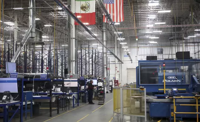 National flags representing the United States and Mexico hang inside in a textile factory that produces T-shirts, in Ciudad Juarez, Mexico, Tuesday, Feb. 4, 2025. (AP Photo/Christian Chavez)