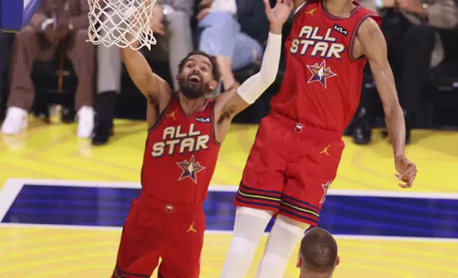 San Antonio Spurs center Victor Wembanyama dunks past teammates Trae Young and Nikola Jokic during the NBA All-Star basketball game Sunday, Feb. 16, 2025, in San Francisco. (AP Photo/Jed Jacobsohn)