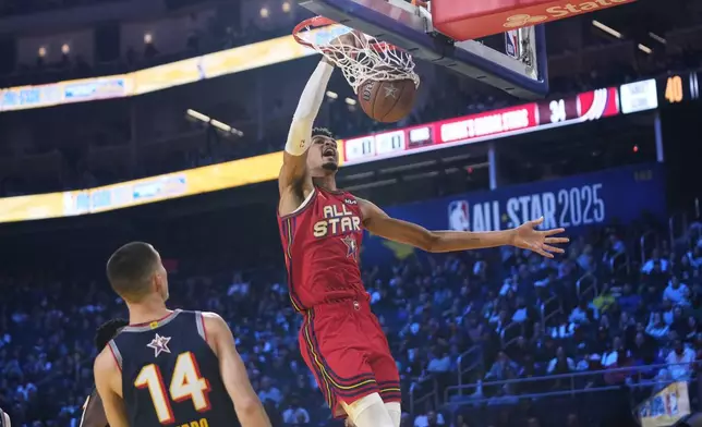 San Antonio Spurs center Victor Wembanyama dunks past Miami Heat guard Tyler Herro during the NBA All-Star basketball game Sunday, Feb. 16, 2025, in San Francisco. (AP Photo/Godofredo A. Vásquez)