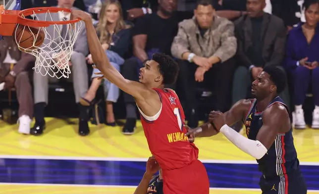 San Antonio Spurs center Victor Wembanyama dunks past Memphis Grizzlies forward Jaren Jackson Jr. during the NBA All-Star basketball game Sunday, Feb. 16, 2025, in San Francisco. (AP Photo/Jed Jacobsohn)
