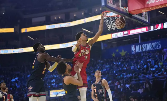 San Antonio Spurs center Victor Wembanyama dunks over Detroit Pistons guard Cade Cunningham during the NBA All-Star basketball game Sunday, Feb. 16, 2025, in San Francisco. (AP Photo/Godofredo A. Vásquez)
