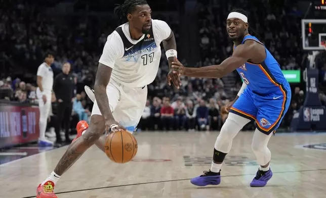 Minnesota Timberwolves center Naz Reid (11) works toward the basket as Oklahoma City Thunder guard Luguentz Dort (5) defends during the first half of an NBA basketball game, Thursday, Feb. 13, 2025, in Minneapolis. (AP Photo/Abbie Parr)