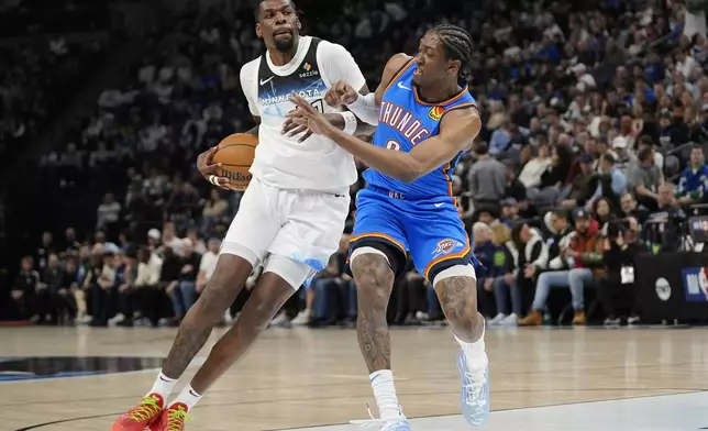 Minnesota Timberwolves center Naz Reid (11), left, works toward the basket as Oklahoma City Thunder forward Jalen Williams (8) defends during the first half of an NBA basketball game, Thursday, Feb. 13, 2025, in Minneapolis. (AP Photo/Abbie Parr)