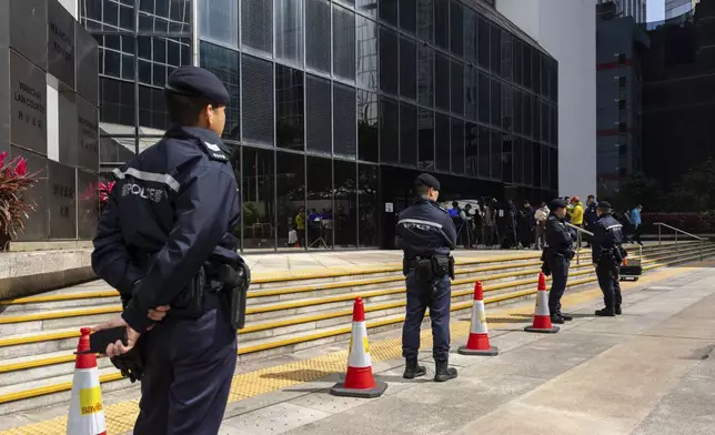 Police officers stand guard outside the District Court ahead of the sentencing on a riot case involving a former pro-democracy lawmaker Lam Cheuk-ting in Wan Chai, Hong Kong on Thursday, Feb. 27, 2025. (AP Photo/Chan Long Hei)