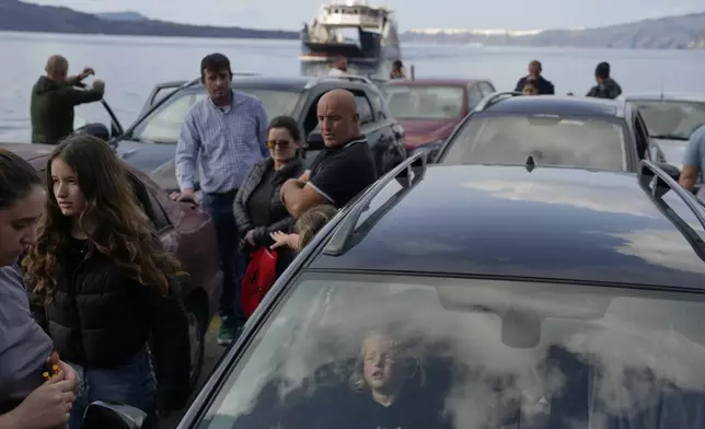 People wait for the arrival of a regularly scheduled ferry to Athens' port of Piraeus, after a spike in seismic activity raised concerns about a potentially powerful earthquake in Santorini, southern Greece, Monday, Feb. 3, 2025. (AP Photo/Petros Giannakouris)