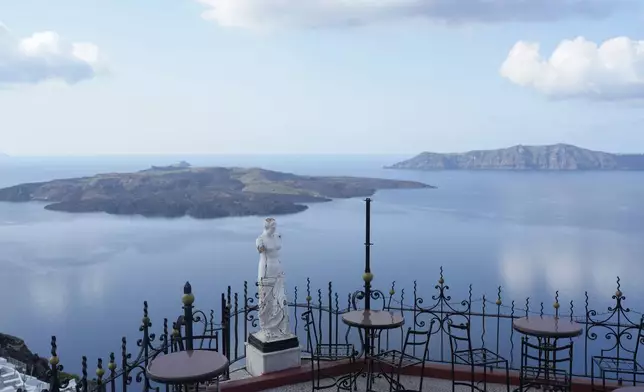 The volcanic island of Nea Kameni, left, is seen from Fira town as Greek authorities are taking emergency measures in response to intense seismic activity on the popular Aegean Sea holiday island of Santorini, southern Greece, Monday, Feb. 3, 2025. (AP Photo/Petros Giannakouris)