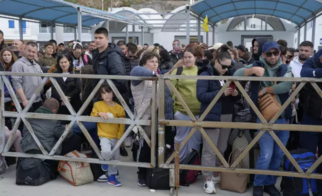 People wait for the arrival of a regularly scheduled ferry to Athens' port of Piraeus, after a spike in seismic activity raised concerns about a potentially powerful earthquake in Santorini, southern Greece, Monday, Feb. 3, 2025. (AP Photo/Petros Giannakouris)