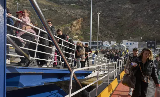 Passengers board a regularly scheduled ferry to Athens' port of Piraeus, after a spike in seismic activity raised concerns about a potentially powerful earthquake in Santorini, southern Greece, Monday, Feb. 3, 2025. (AP Photo/Petros Giannakouris)