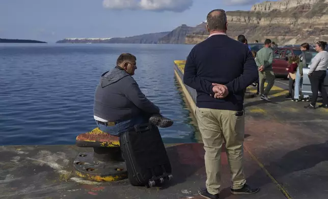 Passengers wait for the arrival of a regularly scheduled ferry to Athens' port of Piraeus, after a spike in seismic activity raised concerns about a potentially powerful earthquake in Santorini, southern Greece, Monday, Feb. 3, 2025. (AP Photo/Petros Giannakouris)