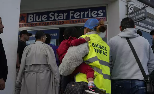 People wait to buy boat and air tickets as Greek authorities are taking emergency measures in response to intense seismic activity on the popular Aegean Sea holiday island of Santorini, southern Greece, Monday, Feb. 3, 2025. (AP Photo/Petros Giannakouris)