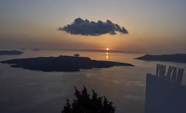 The sun sets behind the volcanic island of Nea Kameni, as authorities take emergency measures in response to intense seismic activity on the popular Aegean Sea holiday island of Santorini, southern Greece, Monday, Feb. 3, 2025. (AP Photo/Petros Giannakouris)