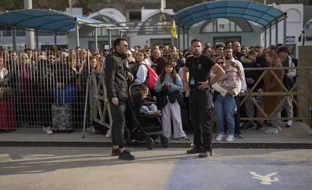 Passengers wait for the arrival of a regularly scheduled ferry to Athens' port of Piraeus, after a spike in seismic activity raised concerns about a potentially powerful earthquake in Santorini, southern Greece, Monday, Feb. 3, 2025. (AP Photo/Petros Giannakouris)