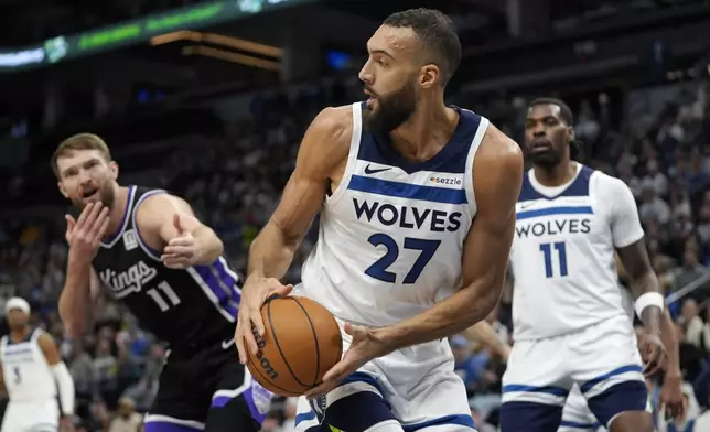 Minnesota Timberwolves center Rudy Gobert (27) grabs a rebound as Sacramento Kings forward Domantas Sabonis, left, reacts after not receiving a foul call during the first half of an NBA basketball game, Monday, Feb. 3, 2025, in Minneapolis. (AP Photo/Abbie Parr)