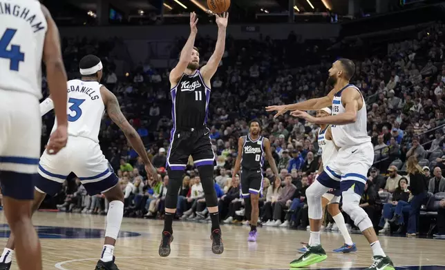 Sacramento Kings forward Domantas Sabonis (11) shoots over Minnesota Timberwolves center Rudy Gobert (27), right, during the first half of an NBA basketball game, Monday, Feb. 3, 2025, in Minneapolis. (AP Photo/Abbie Parr)