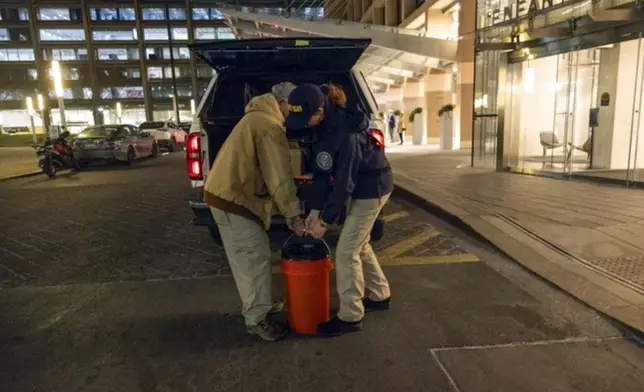 In this image provided by the National Transportation Safety Board, NTSB investigators deliver the cockpit voice recorder and flight data recorder to NTSB headquarters in Washington, Thursday, Jan. 30, 2025, that were recovered from the American Airlines passenger jet that crashed with an Army helicopter Wednesday night near Ronald Reagan Washington National Airport. (NTSB via AP)