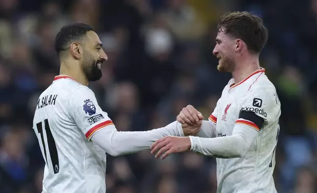 Liverpool's Mohamed Salah, left, celebrates with Liverpool's Alexis Mac Allister after scoring the opening goal during the English Premier League soccer match between Aston Villa and Liverpool at Villa Park in Birmingham, England, Wednesday, Feb. 19, 2025. (AP Photo/Darren Staples)