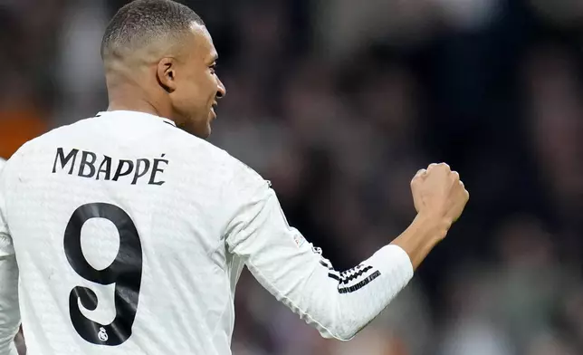 Real Madrid's Kylian Mbappe celebrates after scoring his sides third goal during the Champions League playoff second leg soccer match between Real Madrid and Manchester City at the Santiago Bernabeu Stadium in Madrid, Spain, Wednesday, Feb. 19, 2025. (AP Photo/Manu Fernandez)