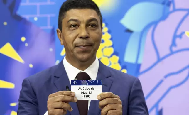 Brazilian former player Giovane Elber shows the ticket of Spanish club Atletico de Madrid, during the UEFA Champions League round of 16, quarter-final and semi-final draws, at the UEFA headquarters in Nyon, Switzerland, Friday, Feb. 21, 2025. (Salvatore Di Nolfi/Keystone via AP)