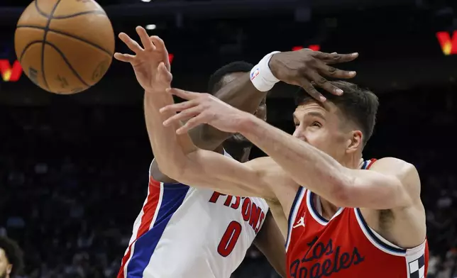 Los Angeles Clippers guard Bogdan Bogdanovic, right, passes the ball against Detroit Pistons center Jalen Duren (0) during the first half of an NBA basketball game Monday, Feb. 24, 2025, in Detroit. (AP Photo/Duane Burleson)