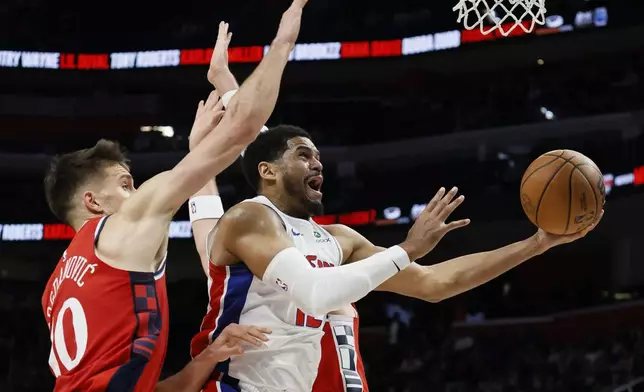 Detroit Pistons forward Tobias Harris, right, goes to the basket between Los Angeles Clippers guard Bogdan Bogdanovic (10) and center Ivica Zubac, right, during the first half of an NBA basketball game Monday, Feb. 24, 2025, in Detroit. (AP Photo/Duane Burleson)