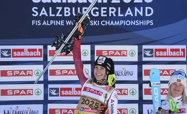 Austria's Stephanie Venier celebrates on the podium after winning a women's Super-G, at the Alpine Ski World Championships, in Saalbach-Hinterglemm, Austria, Thursday, Feb. 6, 2025. At right is third-placed Norway's Kajsa Vickhoff Lie. (AP Photo/Giovanni Auletta)
