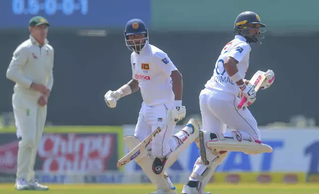 Sri Lanka's Dinesh Chandimal , right, along with his batting partner Dimuth Karunaratne run between the wickets during the second test cricket match between Sri Lanka and Australia in Galle , Sri Lanka, Thursday, Feb. 6, 2025. (AP Photo/Lahiru Harshana)
