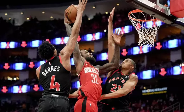 Houston Rockets forward Jeff Green (32) drives to the basket as Toronto Raptors forward Scottie Barnes (4) and center Orlando Robinson, right, defend during the first half of an NBA basketball game Sunday, Feb. 9, 2025, in Houston. (AP Photo/Eric Christian Smith)