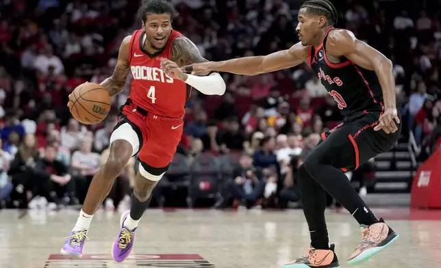 Houston Rockets guard Jalen Green (4) dribbles as Toronto Raptors guard Ochai Agbaji, right, defends during the first half of an NBA basketball game Sunday, Feb. 9, 2025, in Houston. (AP Photo/Eric Christian Smith)