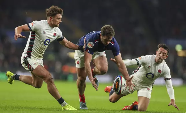 France's Damian Penaud, center, drops the ball challenged by England's Henry Slade, left, and Alex Mitchell during the Six Nations rugby union match between England and France at Twickenham in London, Saturday, Feb. 8, 2025. (AP Photo/Ian Walton)