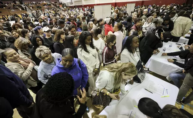 People impacted by the Eaton Fire wait in line to receive a check at the gymnasium of Pasadena City College where The Change Reaction is handing out about 1,000 checks of between $2,500-$5,000, Tuesday, Jan. 28, 2025 in Pasadena, Calif. (AP Photo/Etienne Laurent)