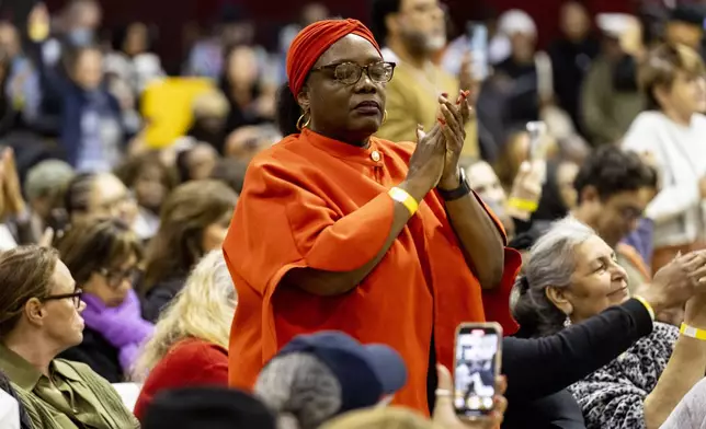 A member of the audience reacts as people impacted by the Eaton Fire attend an event at the gymnasium of Pasadena City College where The Change Reaction will be handing out about 1,000 checks of between $2,500-$5,000, in Pasadena, Tuesday, Jan. 28, 2025 in Pasadena, Calif. (AP Photo/Etienne Laurent)