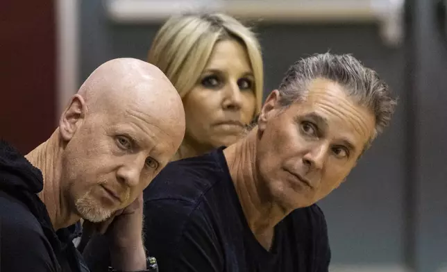 GoFundMe CEO Tim Cadogan, left, The Change Reaction founders Greg Perlman, left, and his wife Jodi attend an event at the gymnasium of Pasadena City College during which The Change Reaction foundation will be handing out about 1,000 checks of between $2,500-$5,000 to people impacted by the Eaton Fire, Tuesday, Jan. 28, 2025 in Pasadena, Calif. (AP Photo/Etienne Laurent)