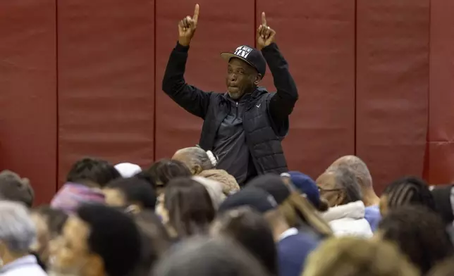A member of the audience reacts as people impacted by the Eaton Fire attend an event at the gymnasium of Pasadena City College where The Change Reaction will be handing out about 1,000 checks of between $2,500-$5,000, Tuesday, Jan. 28, 2025 in Pasadena, Calif. (AP Photo/Etienne Laurent)