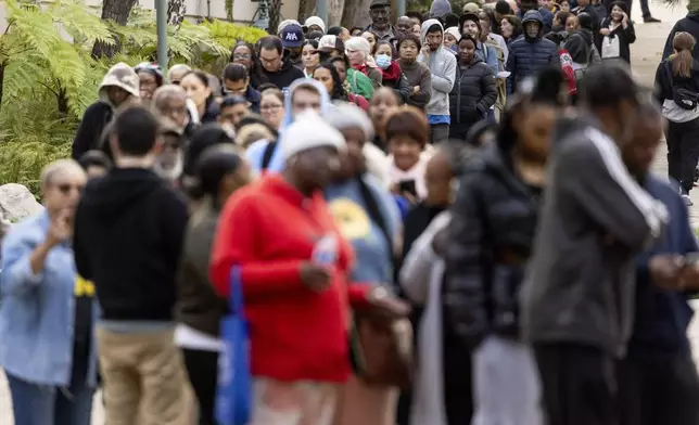 People impacted by the Eaton Fire wait in line to access Pasadena City College's gymnasium, where The Change Reaction will be handing out about 1,000 checks of between $2,500-$5,000, Tuesday, Jan. 28, 2025 in Pasadena, Calif. (AP Photo/Etienne Laurent)