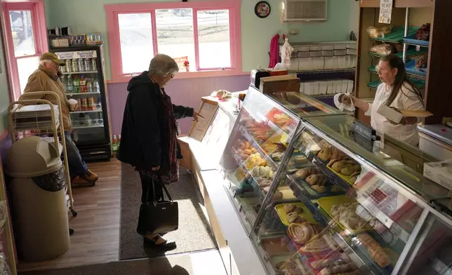 FILE - A customer selects donuts at Leavitt's Country Bakery, in this April 13, 2023, file photo in Conway, N.H. (AP Photo/Robert F. Bukaty, file)