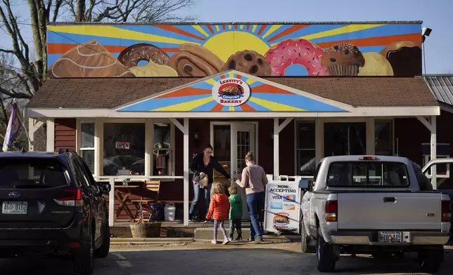 FILE - A customer holds the door for a family arriving at Leavitt's Country Bakery in this April 13, 2023 file photo, in Conway, N.H. (AP Photo/Robert F. Bukaty, file)