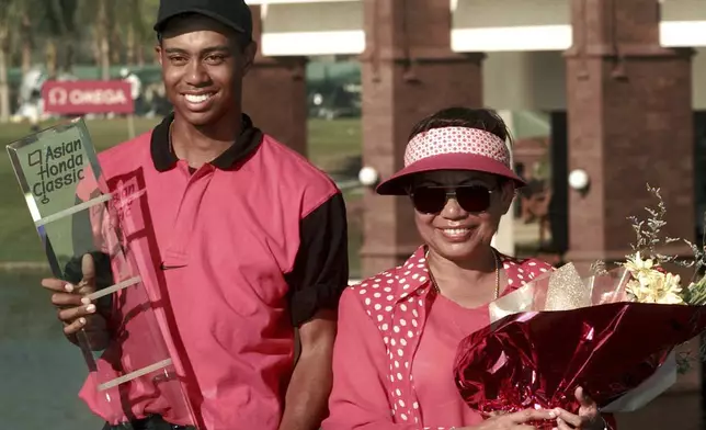 FILE - Golf sensation Tiger Woods, left, poses with his mother Kultida while holding his trophy and key to a new car after winning the Asian Honda Classic in Bangkok, Thailand, Sunday, Feb. 9, 1997. (AP Photo/Charles Dharapak, File)