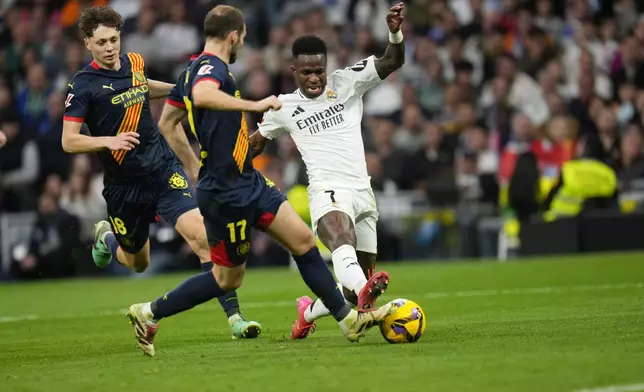 Real Madrid's Vinicius Junior, right, scores his side's second goal during the Spanish La Liga soccer match between Real Madrid and Girona at the Santiago Bernabeu stadium in Madrid, Spain, Sunday, Feb. 23, 2025. (AP Photo/Manu Fernandez)