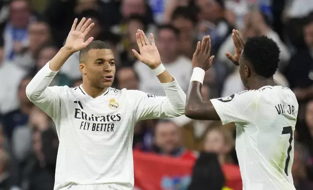Real Madrid's Vinicius Junior, right, celebrates with Kylian Mbappe after scoring his side's second goal during the Spanish La Liga soccer match between Real Madrid and Girona at the Santiago Bernabeu stadium in Madrid, Spain, Sunday, Feb. 23, 2025. (AP Photo/Manu Fernandez)